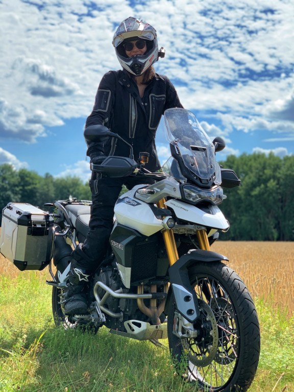 Woman riding Tiger 900 Rally Pro in a field 
