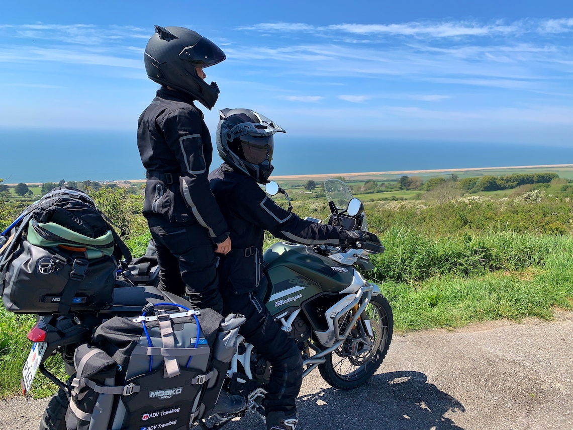 Two women riding the Triumph Tiger 900 Rally Pro two up in Dorset overlooking Westbay